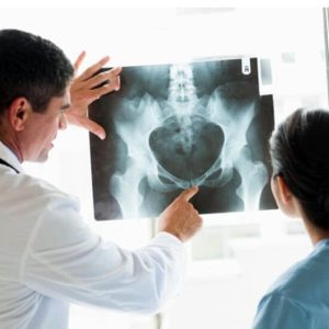 Doktor, hastaya röntgen görüntüsü gösteriyor, evde bakım ve sağlık hizmetleri sunuyor.